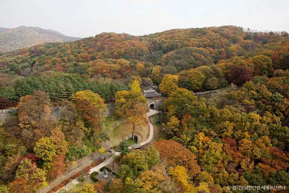 단풍이 든 산자락 사이로 도로와 성문이 보이는 남한산성도립공원 일대
