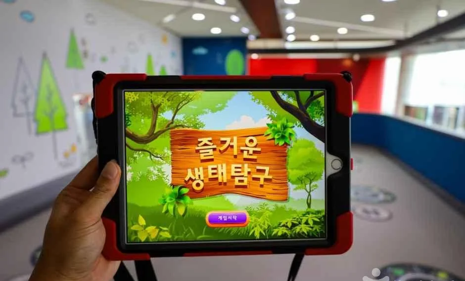 태블릿 화면에 생태탐구 게임 시작 화면이 떠 있는 모습