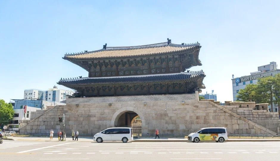 푸른 하늘 아래 우진각 지붕의 2층 성문과 성곽이 있는 흥인지문 광장