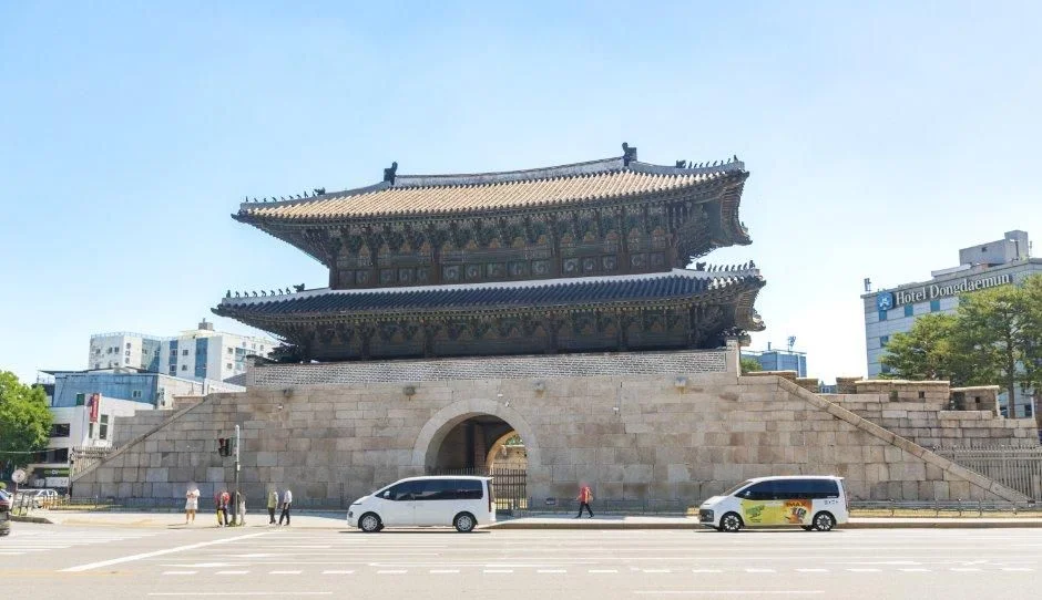 맑은 하늘 아래 흥인지문 정면과 앞 광장, 승합차 두 대