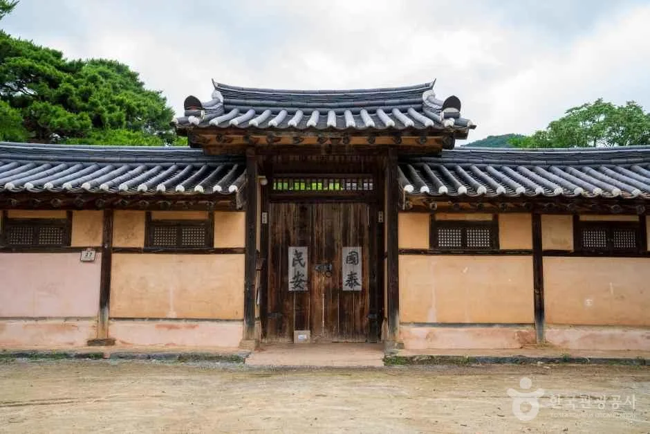 기와 담장 가운데 대문이 있는 한옥 건물 정면