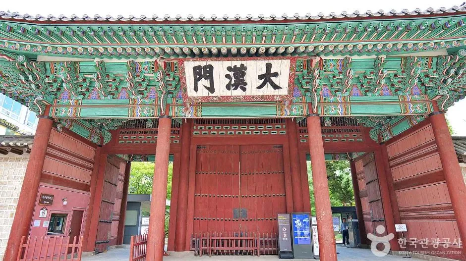 붉은 기둥과 초록 단청의 문에 한자 현판이 걸린 덕수궁 대한문 정면