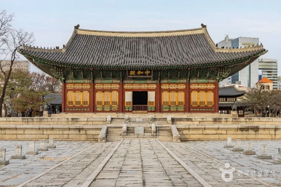 넓은 돌 마당 앞에 2층 지붕을 한 큰 전각이 서 있고 양옆으로 회랑이 이어진 덕수궁 풍경