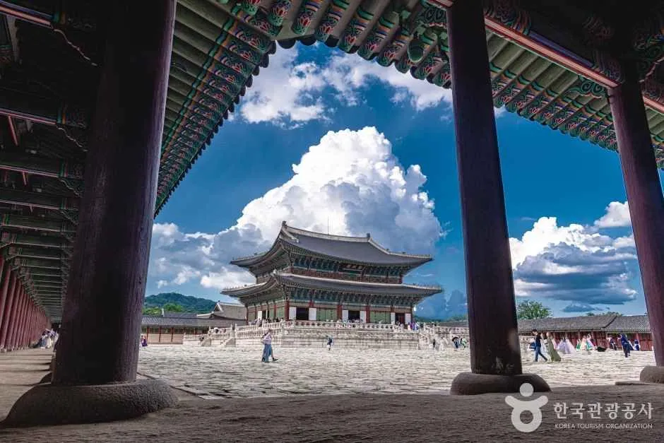 넓은 돌바닥 마당 건너편에 2층 전각이 보이고 마당 가장자리에 관람객이 서 있는 경복궁 풍경