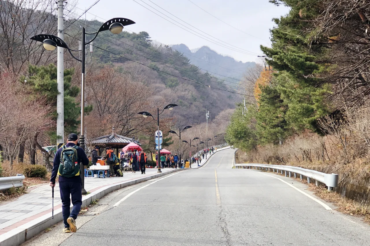 산으로 이어지는 왕복 2차선 진입도로와 가장자리를 걷는 사람