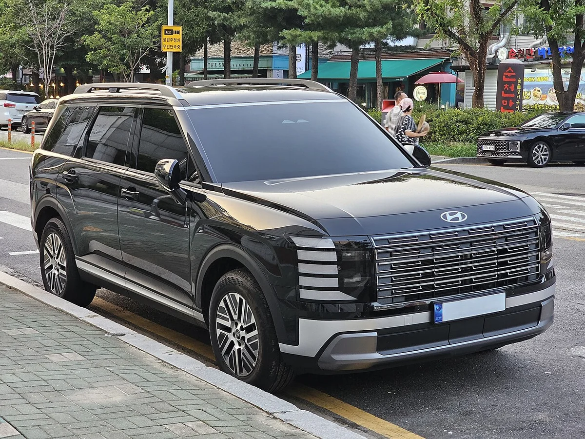 도로변에 세워진 검은색 현대 팰리세이드 하이브리드 익스클루시브의 전면 3/4 모습