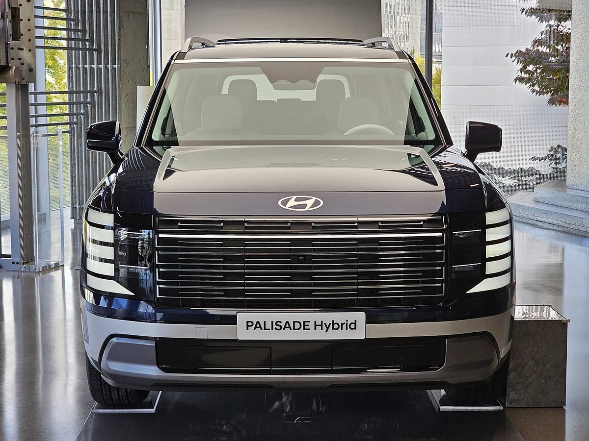 전시장에 놓인 팰리세이드 하이브리드 전면, 앞 범퍼에 PALISADE Hybrid 표지판이 놓여 있다