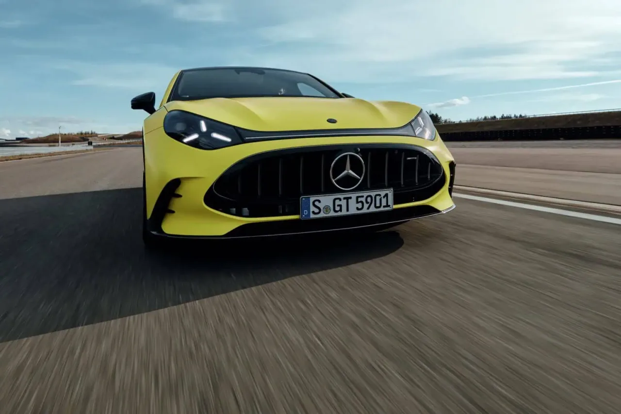 서킷을 주행하는 노란색 메르세데스-AMG GT 4도어 쿠페의 전면 모습