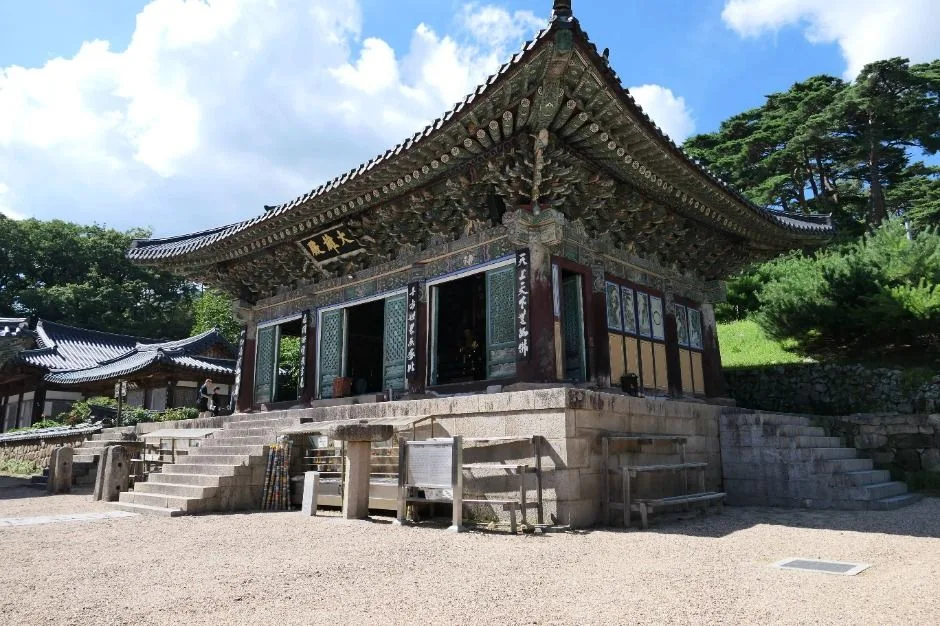 돌 축대 위에 지붕선이 곧게 뻗은 동화사 누각형 전각