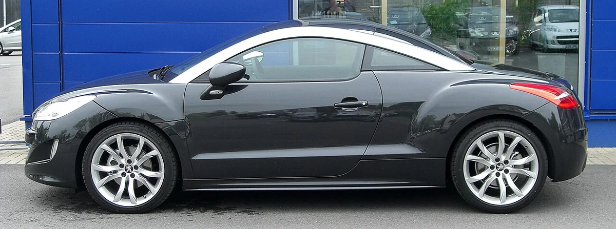 검은색 푸조 RCZ 쿠페의 측면, 낮은 지붕과 알루미늄 루프 아치가 보인다
