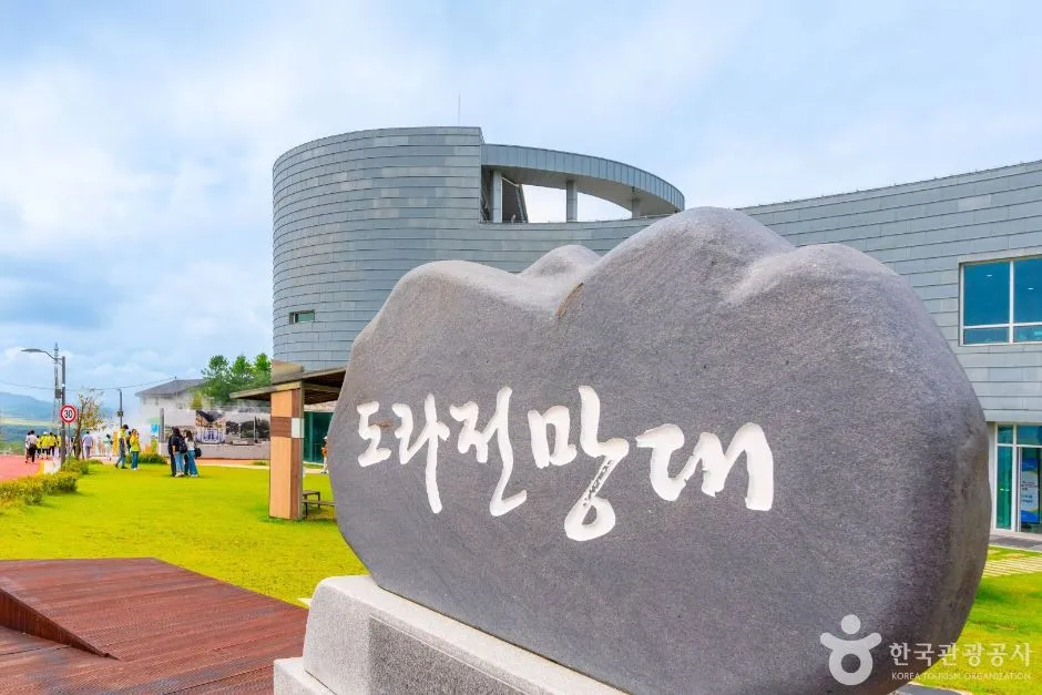 도라전망대 글자가 새겨진 돌 표석과 뒤로 보이는 전망대 건물