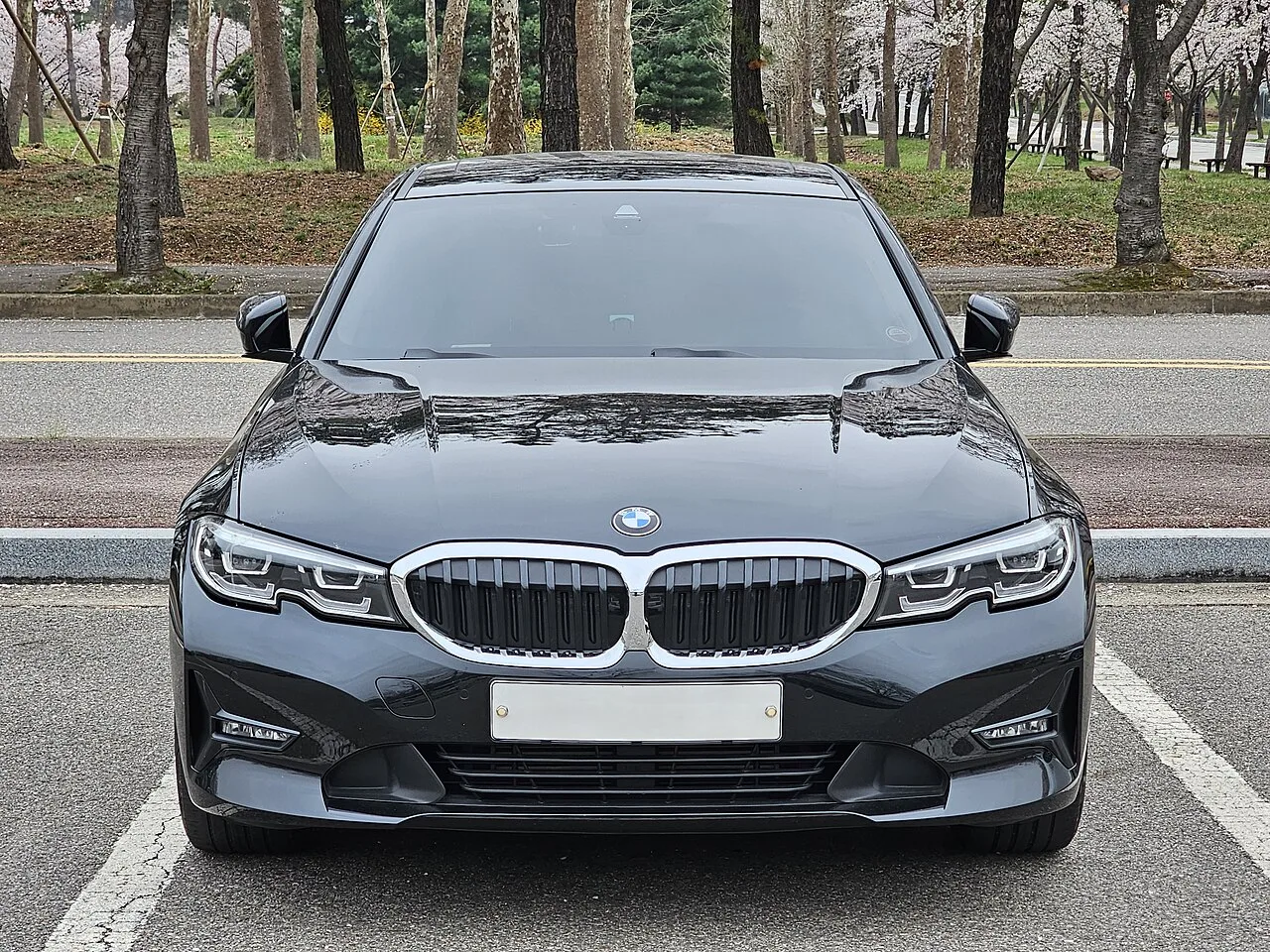 현행 BMW 3시리즈(G20) 실물 사진, 검은색 세단의 전면 정측면 각도