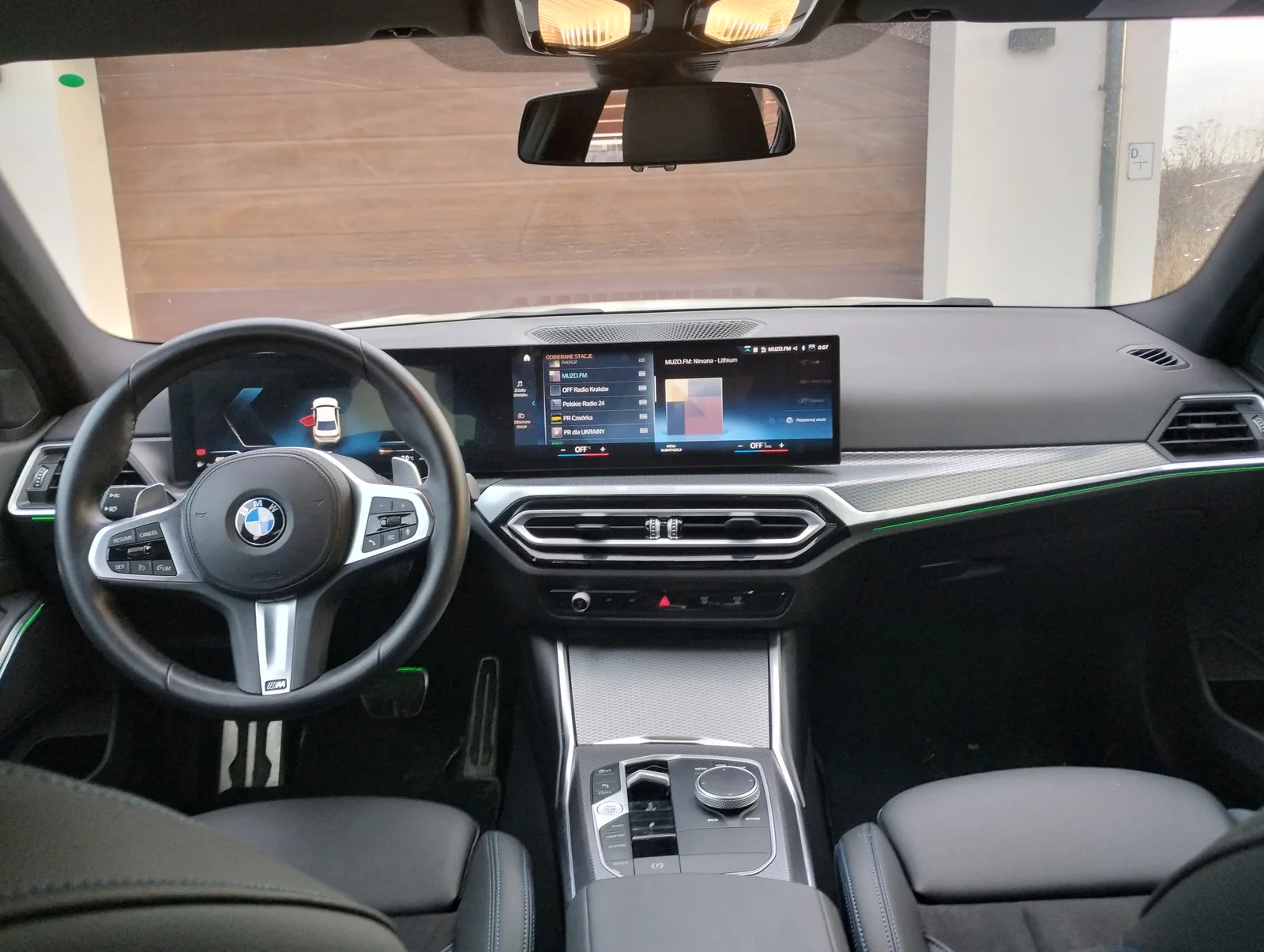 현행 BMW 318i 실내 대시보드, 커브드 디스플레이와 M 스티어링휠이 보인다