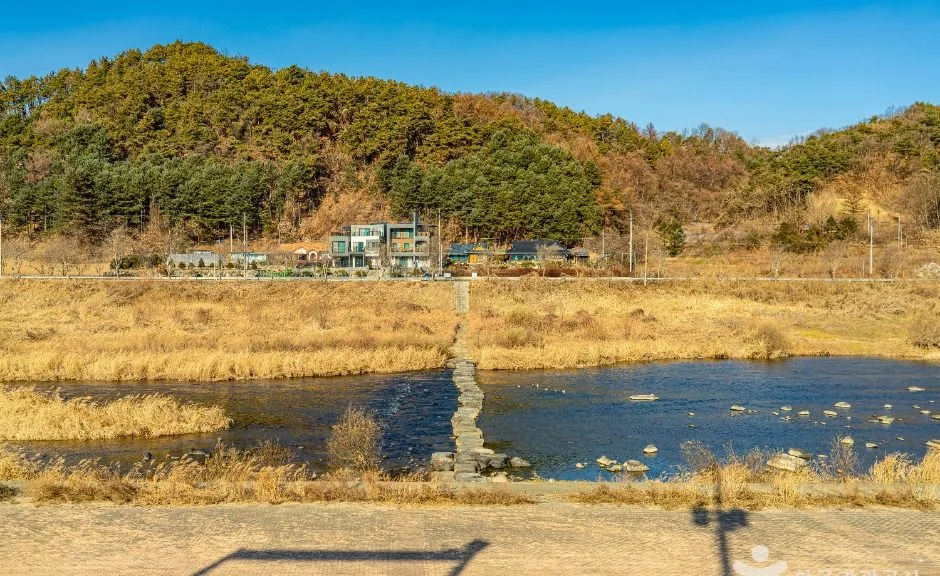 징검다리가 놓인 섬강 물가와 건너편 산등성이