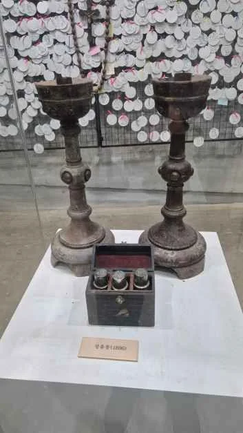 유리 진열대 위에 놓인 촛대 한 쌍과 작은 함