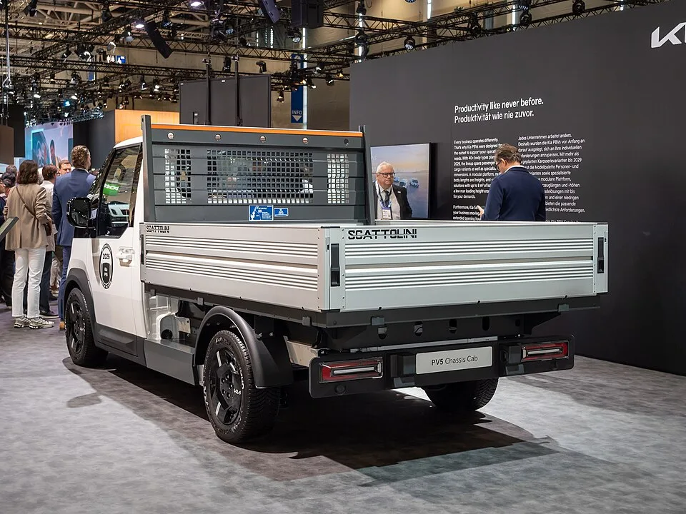 IAA 트랜스포테이션 2026 하노버 전시장에 놓인 기아 PV5 섀시캡 뒷모습, 범퍼 아래에 'PV5 Chassis Cab' 명판이 보이고 화물칸에는 스카톨리니(Scattolini)사의 드롭사이드형 알루미늄 적재함이 장착돼 있다