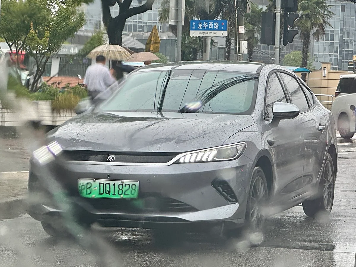 회색 친 플러스 2세대 EV 전면, 빗길에 서 있는 전측면
