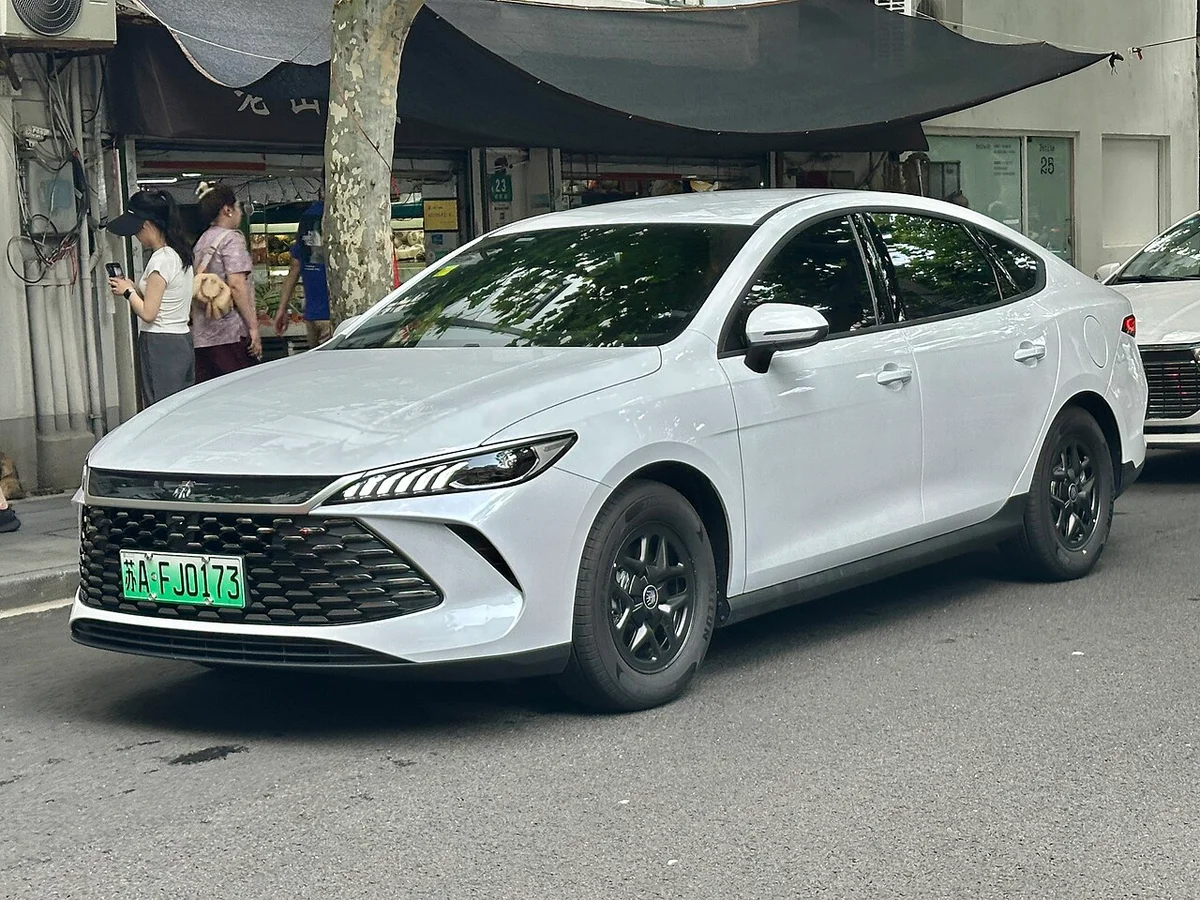 흰색 BYD 친 플러스 2세대 DM-i 전면, 검은 그릴과 가로형 헤드램프가 보이는 전측면