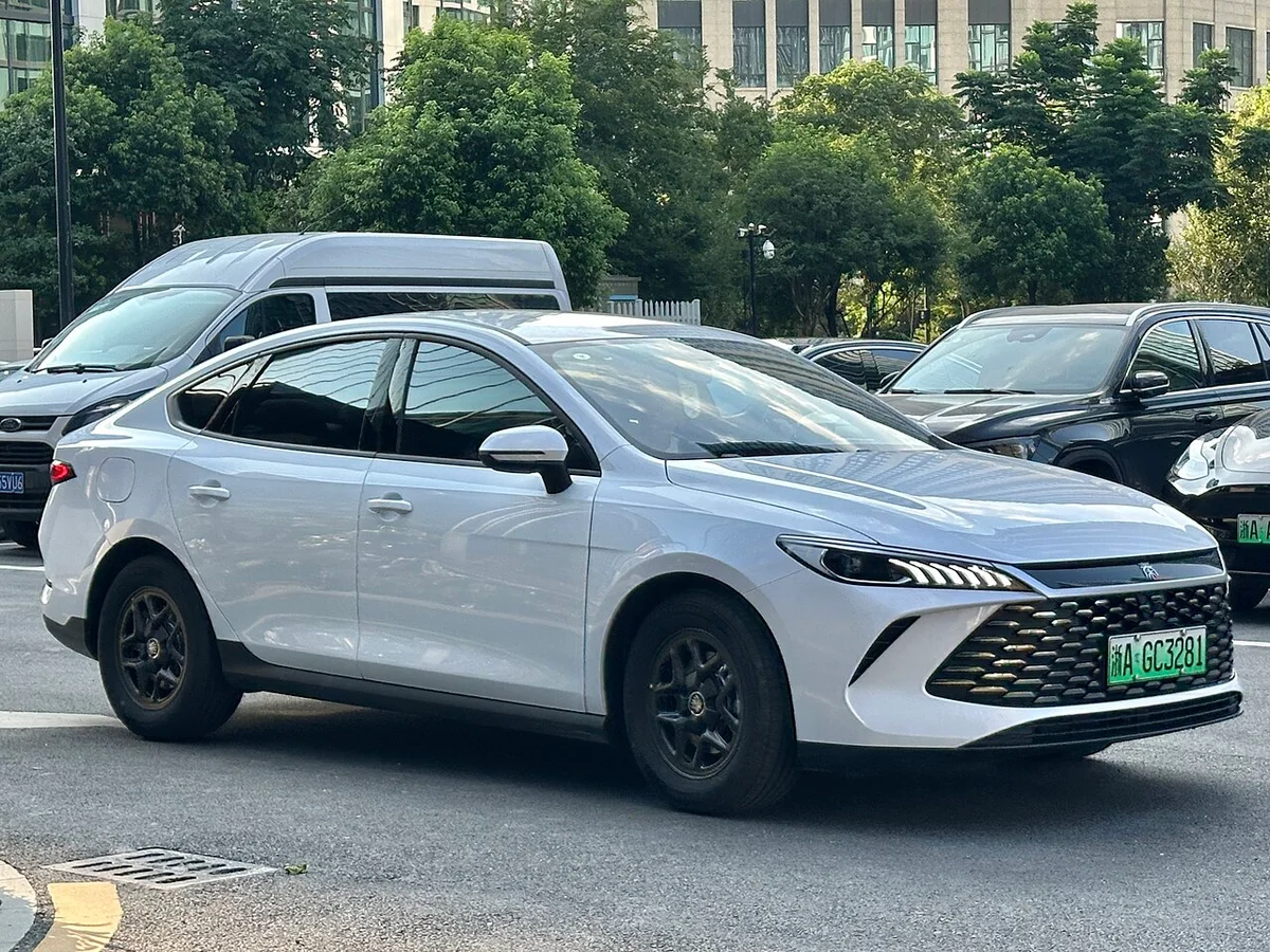 은회색 BYD 친 플러스 2세대 DM-i 전측면, 가로형 헤드램프와 검은 그릴