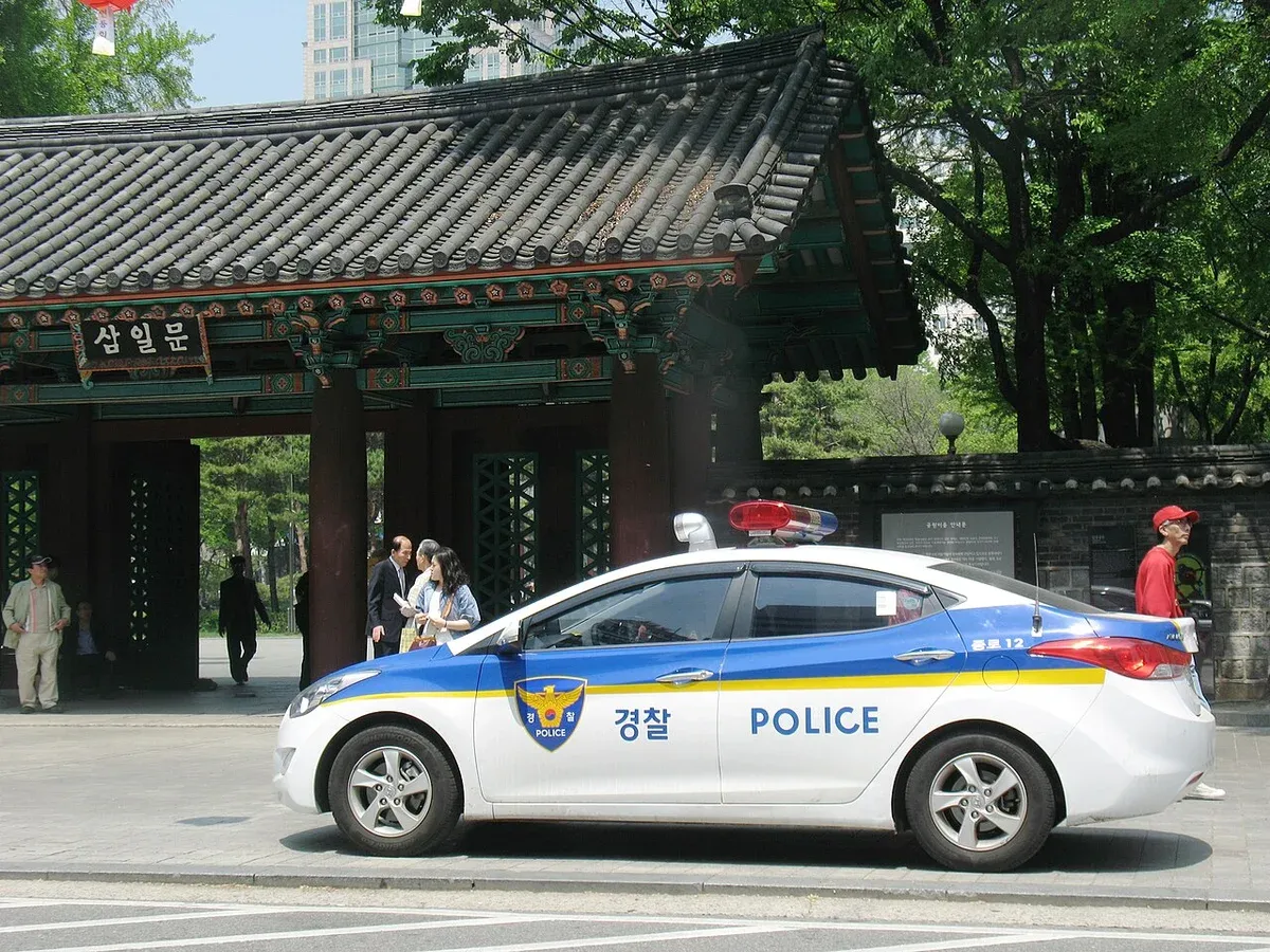 서울 도심의 건물 앞길에 서 있는 파랑·흰색 경찰차