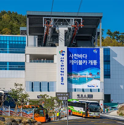 '사천바다케이블카 개통' 현수막이 걸린 대방정류장 건물 외경과 케이블카 승강장