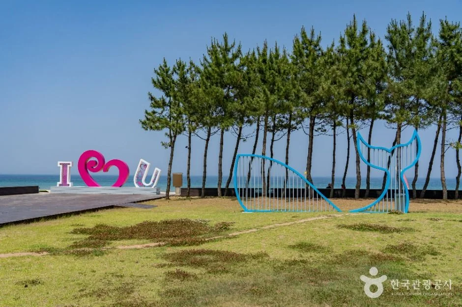 잔디밭과 소나무 숲, 하트 조형물이 있는 증산해변 인근 공원