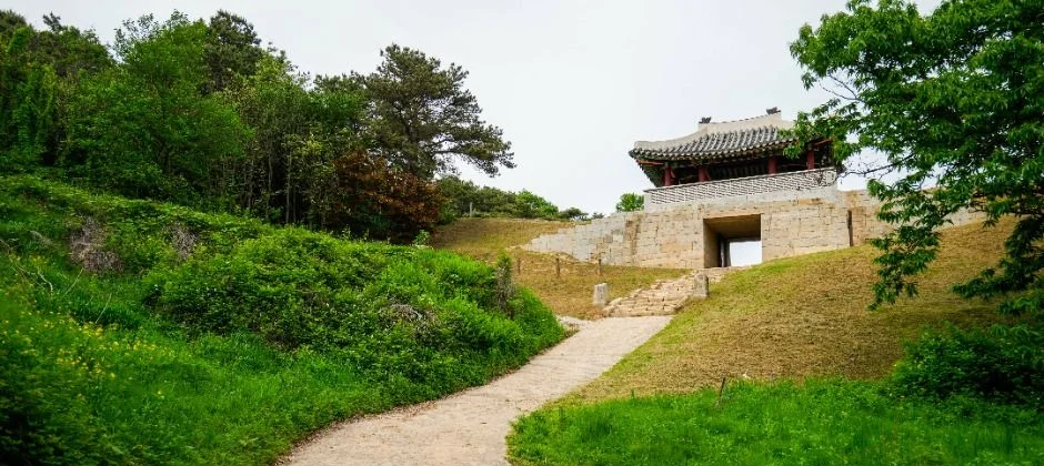 흙길 산책로 끝에 보이는 상당산성의 성문과 문루