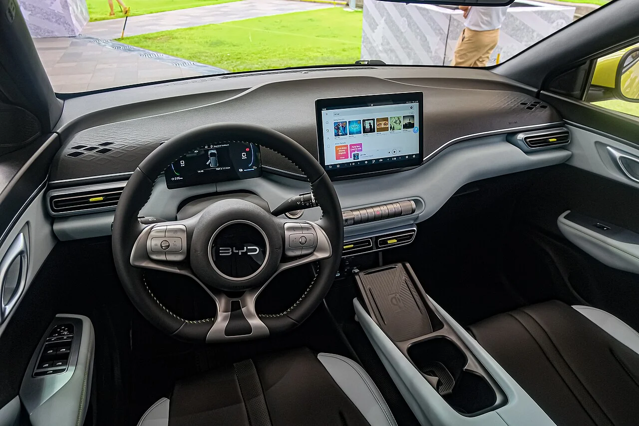 BYD 씨걸 1세대 실내, 스티어링 휠 뒤 계기판과 중앙 터치스크린, 센터 컵홀더가 보인다