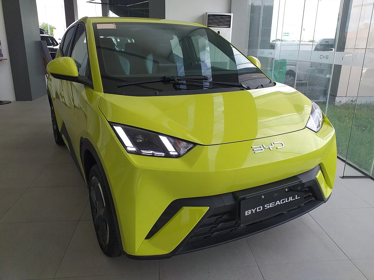 노란색 BYD 씨걸 1세대의 전면 모습, 실내 전시장에 놓여 있다