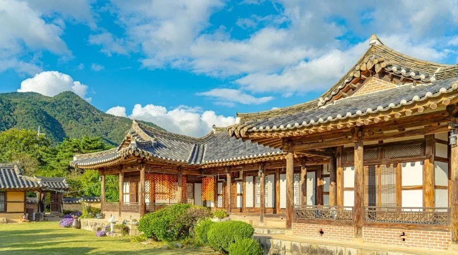 푸른 하늘 아래 넓게 펼쳐진 고택 본채 전경