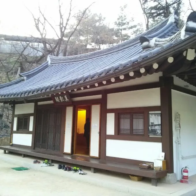 기와지붕을 얹은 한옥 건물 처마 아래 '진영각'이라 쓰인 현판이 걸려 있고 문이 열려 있다