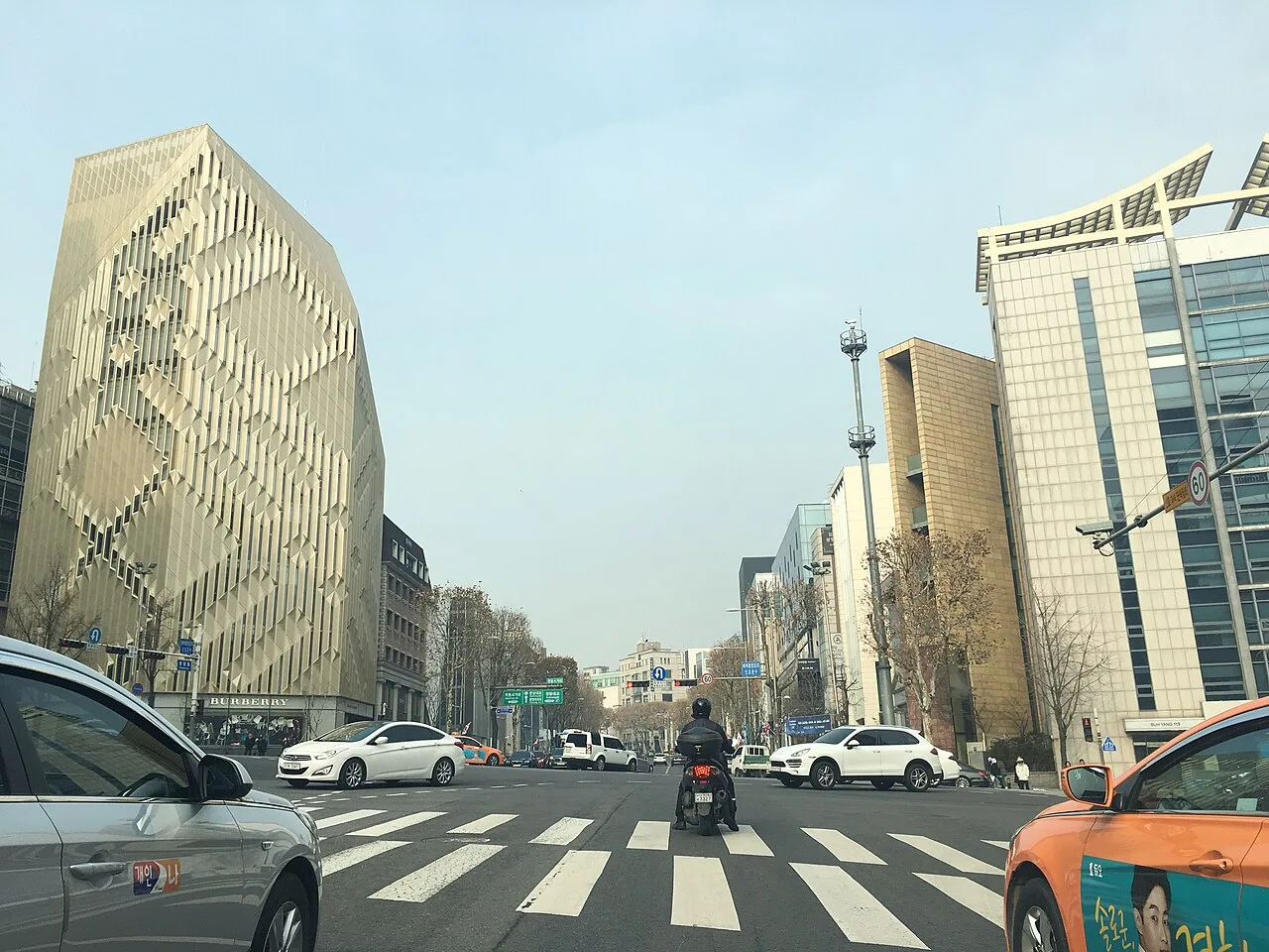 서울 청담동 사거리의 횡단보도와 정지선 앞에서 신호를 기다리는 승용차와 택시