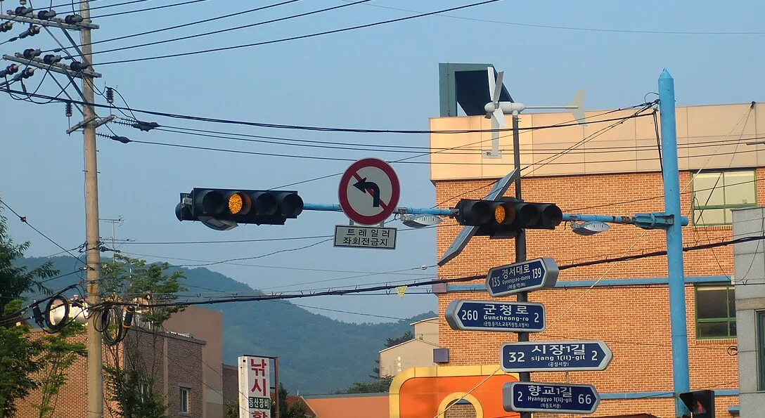 황색 등화가 켜진 차량 신호등과 좌회전 금지 표지가 걸린 교차로 신호 기둥