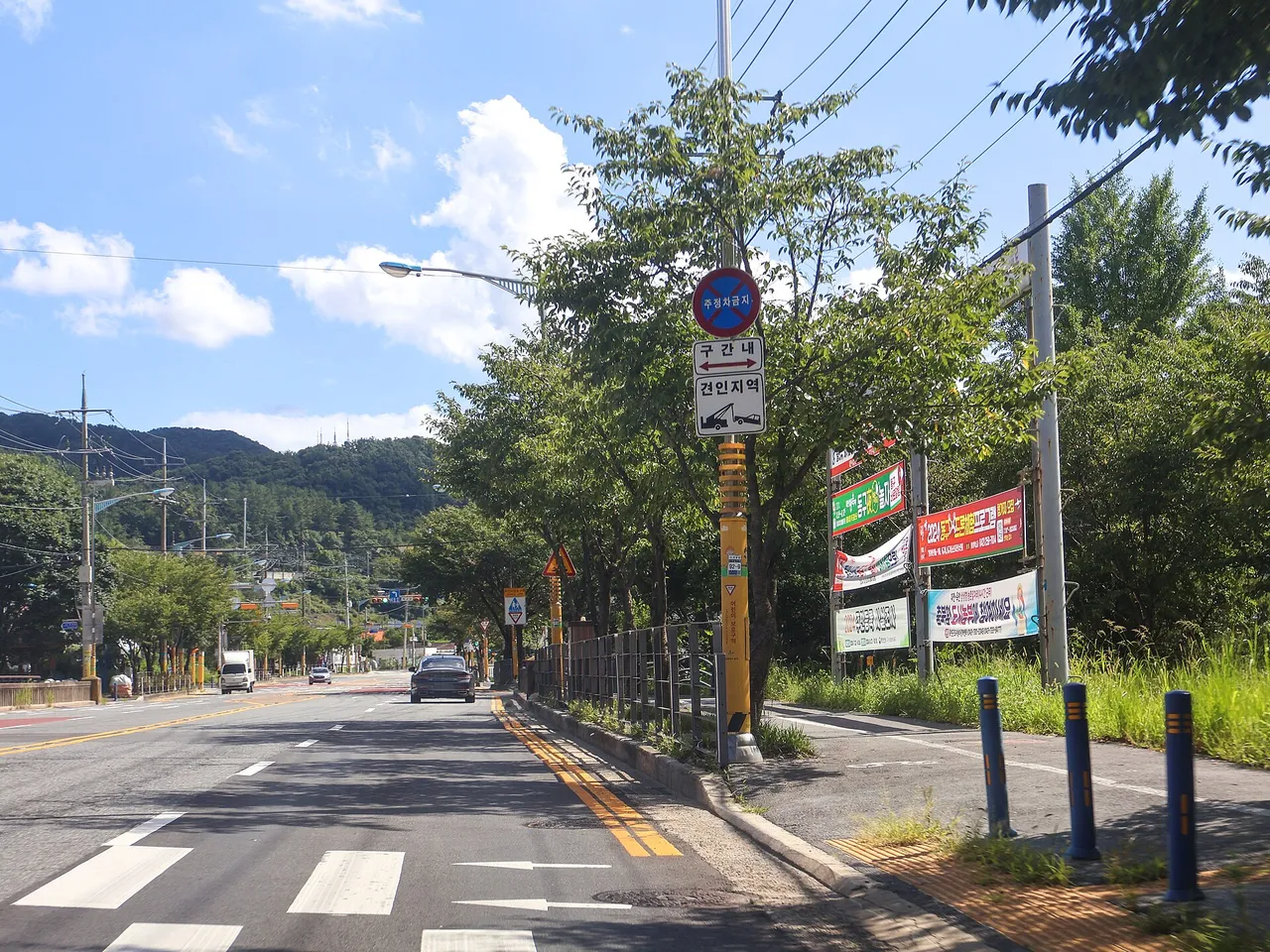 어린이보호구역 표지와 노란 노면 표시, 횡단보도가 있는 도로