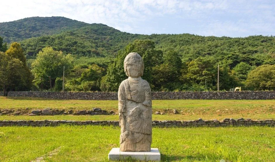 잔디 위 기단 위에 서 있는 석불입상