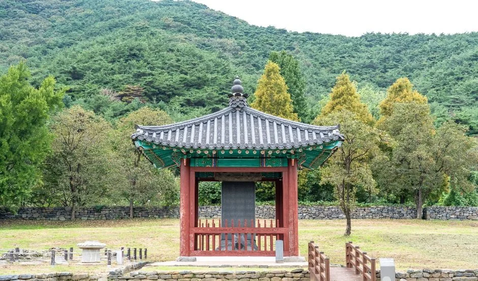 푸른 숲을 배경으로 한 붉은 기둥의 정자 모양 전각과 석탑