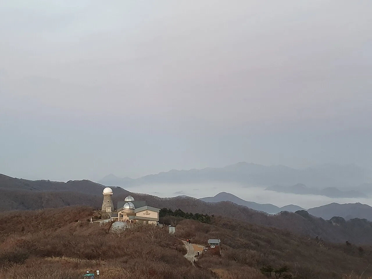 구름바다 위로 솟은 능선에 자리한 소백산천문대 관측돔 두 개와 부속 건물, 제2연화봉에서 바라본 모습