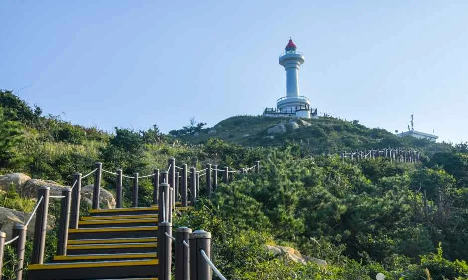 데크 계단 위로 등대섬 정상의 등대가 보이는 풍경