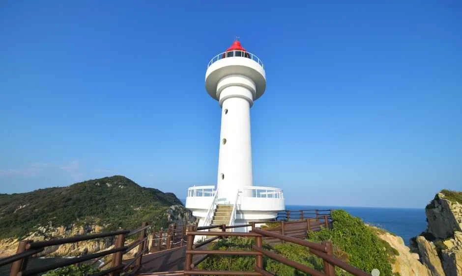 푸른 하늘 아래 절벽 위에 선 흰색 소매물도 등대