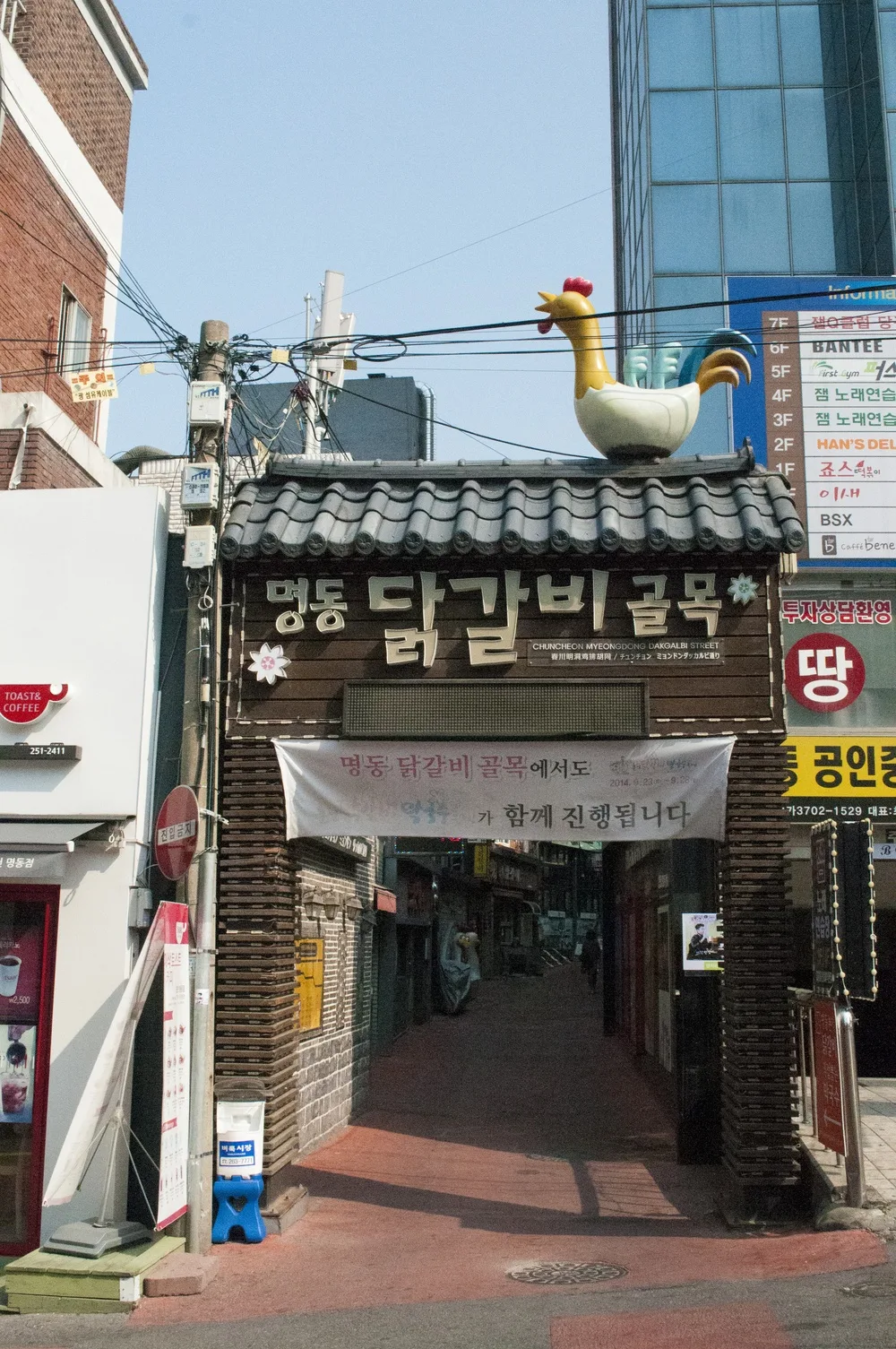 기와지붕과 대형 닭 조형물이 얹힌 춘천 명동 닭갈비골목 입구 게이트