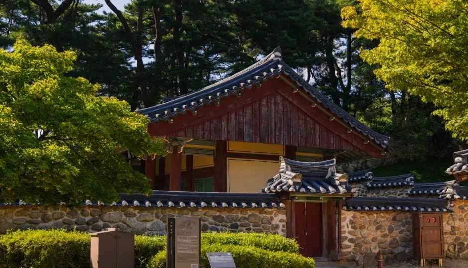 돌담과 기와 담장 너머로 붉은 판벽의 한옥 건물 지붕이 보이는 소수서원 경내