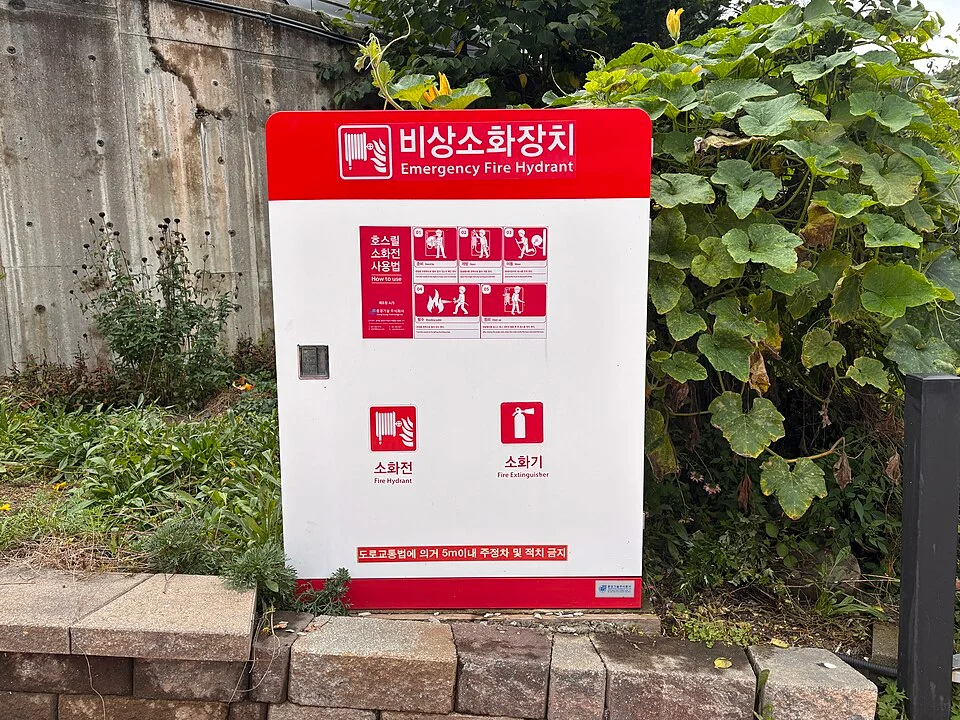 담벼락 앞에 설치된 흰색 비상소화장치함