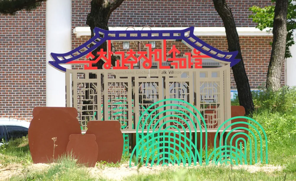 순창고추장민속마을 입구에 세워진 기와지붕 모양 입간판, 한글과 영문으로 'Sunchang Gochujang Folk Village'라고 적혀 있다