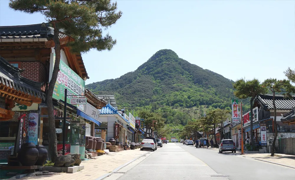 한옥 건물이 늘어선 순창고추장민속마을 거리, 뒤로 보이는 아미산 봉우리