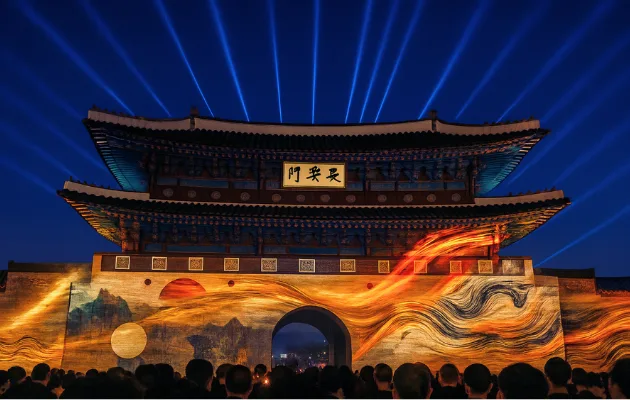 장안문 성문에 붉은 불꽃 형상의 미디어아트가 투사되고 그 앞으로 관람객들이 모여 있는 야간 모습
