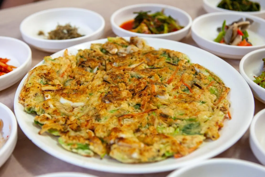 다양한 밑반찬과 함께 차려진 해물파전 한 접시