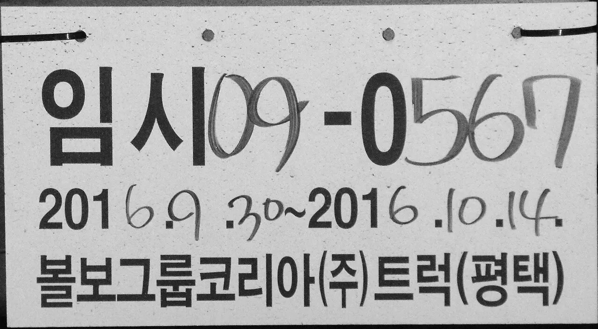 볼보그룹코리아 트럭 평택 명의의 플라스틱 임시번호판에 임시 09-0567과 허가기간이 손글씨로 적힌 모습