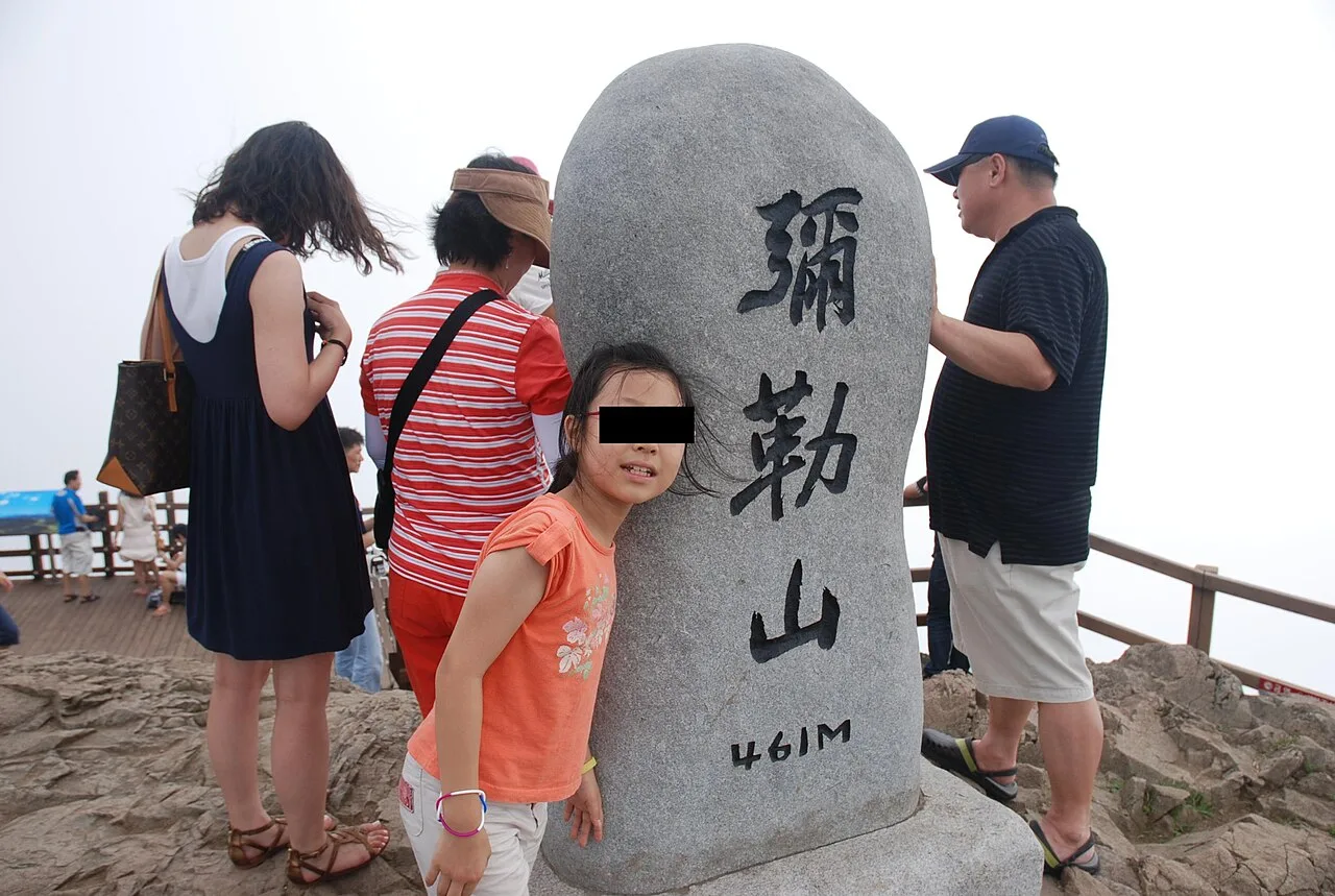 461m 높이를 표시한 미륵산 정상 표지석 앞에 모인 방문객들
