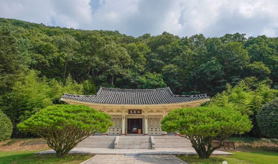 숲을 배경으로 한 기와지붕 건물