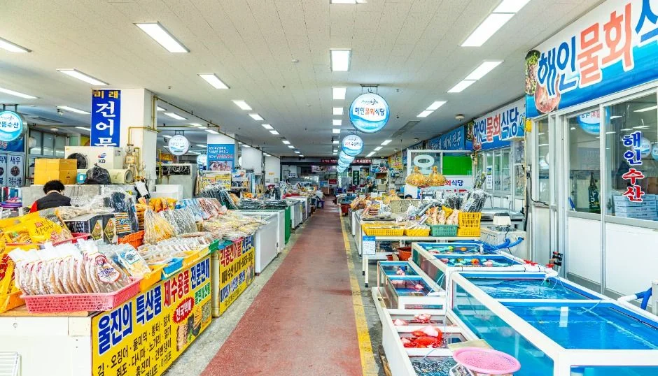 수조와 상점이 늘어선 건물 안 수산물시장 통로